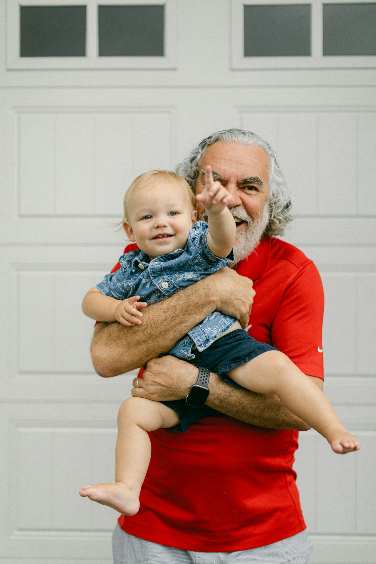Joyful grandfather holding his laughing grandson
